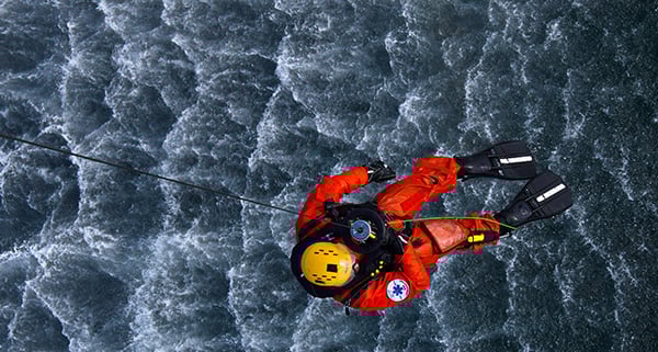 High Angle View Of Rescue Worker Over Water Hanging From Rope